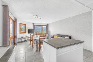 a kitchen and living room with a table and chairs at Appartement T3 in Embrun