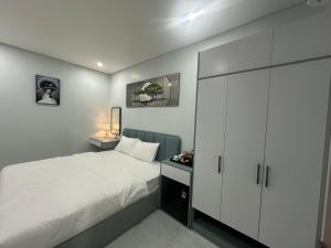 富国Alex House的卧室配有白色的床和橱柜。