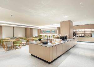 a restaurant with a cafeteria with tables and chairs at JI Hotel Shanghai Baoyang Road Subway Station in Baoshan +10 photos