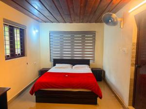 a bedroom with a bed with a red blanket at Wayanad Shas Villa in Padinjarathara +36 photos