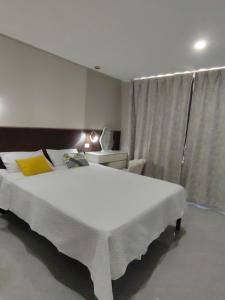 南迪Helen House一间带独立卫生间的温馨卧室的卧室里有一张白色的大床和一扇窗户