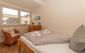 博尔Aussicht的一间卧室，里面有一张床、一把椅子和一扇窗户 更多6张照片