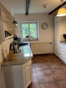 une cuisine avec un comptoir et une horloge au mur dans l'établissement Neu! Alter Kornspeicher, à Bönen