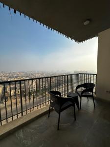 un balcon avec deux chaises et une vue sur une ville dans l'établissement شقة فندقيه ابراج zedالشيخ زايد, à Sheikh Zayed
