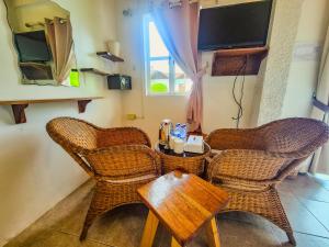 two wicker chairs and a table in a room at SunzEn Palawan, Resort in Coron