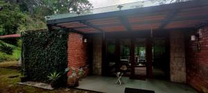 une maison en briques avec un auvent sur un patio dans l'établissement RGS Bungalow Munnar, à Devikolam