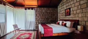 une chambre avec un lit et un mur de briques dans l'établissement RGS Bungalow Munnar, à Devikolam