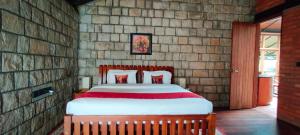 une chambre avec un grand lit dans un mur de briques dans l'établissement RGS Bungalow Munnar, à Devikolam 20 autres photos