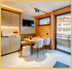 una cucina e una sala da pranzo con tavolo e sedie di L'Élégance Alpine I Centre Les Gets a Les Gets