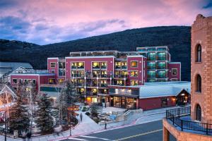 a large pink building with a mountain in the background at Main & SKY by EXMAR in Park City