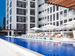 Una piscina de hotel con tumbonas y sombrillas. en The Johnson Brisbane - Art Series, en Brisbane
