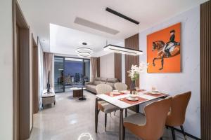 a living room with a table and chairs and a couch at 来咖民宿酒店三亚市中心大悦城店 in Sanya