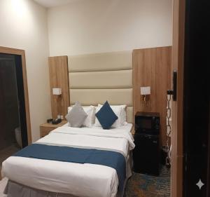 a hotel room with a large bed with blue pillows at Sunday Luxury Central formerly Anan hotel in Riyadh +54 photos