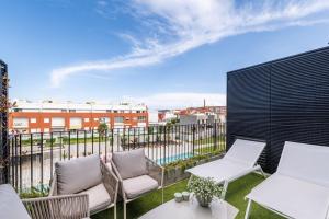 a patio with chairs and tables on a balcony at Riverside duplex by the sea with pool and balcony in Fão +21 photos