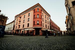 蒂米什瓦拉Old Town Hotel的鹅卵石街道上的一座大型橙色建筑