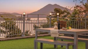 une table et un banc sur un balcon avec vue dans l'établissement Yeosu dasi bom pension, à Yeosu