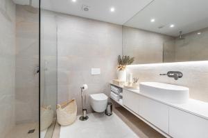 a bathroom with a sink and a shower at Riverside duplex by the sea with pool and balcony in Fão