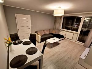 a living room with a couch and a table at Gdańsk - Quiet area with a sea view in Gdańsk