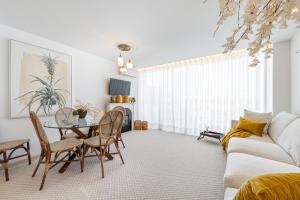 a living room with a table and chairs and a couch at Riverside duplex by the sea with pool and balcony in Fão