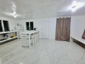 eine Küche mit weißen Wänden und einem weißen Fliesenboden in der Unterkunft Kava Cottage - Entire Place in Nuku‘alofa