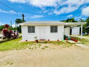 ein kleines weißes Haus auf einer unbefestigten Straße in der Unterkunft Kava Cottage - Entire Place in Nuku‘alofa + 1 Foto