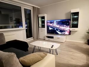a living room with a large flat screen tv at Gdańsk - Quiet area with a sea view in Gdańsk