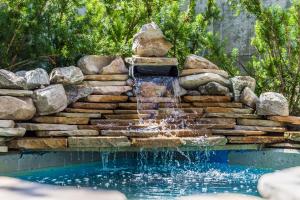 a waterfall in a pool with rocks and a fountain at Main & SKY by EXMAR in Park City