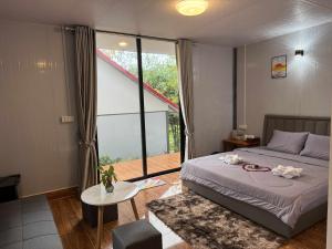 a bedroom with a bed and a large window at SODANY RESORT Kohrong in Koh Rong