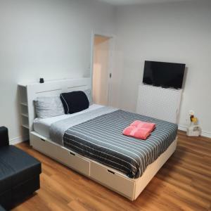 a bedroom with a large bed with a television at Sweet Home in Bloor Downtown-CENTRAL STAY in Toronto
