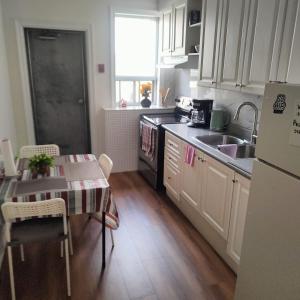 a kitchen with a table and a sink and a refrigerator at Sweet Home in Bloor Downtown-CENTRAL STAY in Toronto