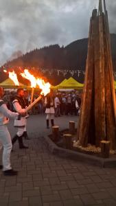 a group of people standing around with fire at Vila Bucovina in Ciocăneşti