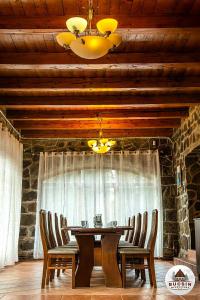 een eetkamer met een houten tafel en stoelen bij Bucsin menedékház in Bucin