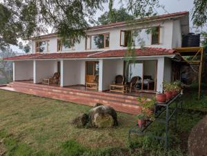 une maison avec un rocher en face dans l'établissement Moksha at Infinity Valley, à Kotagiri