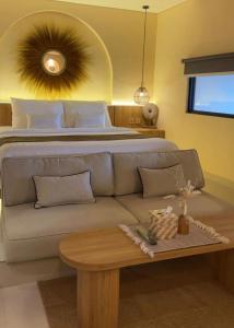 a bedroom with a bed and a couch and a table at Andara Villa Yogyakarta in Yogyakarta