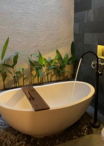 a bath tub with plants in a bathroom at Andara Villa Yogyakarta in Yogyakarta