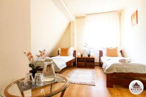 een slaapkamer met 2 bedden en een glazen tafel bij Bucsin menedékház in Bucin +34 foto's