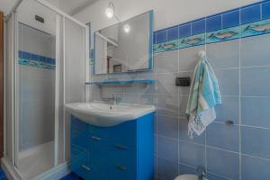 a blue bathroom with a sink and a mirror at Silvia sul Lungomare di Campo in Marina di Campo +21 photos