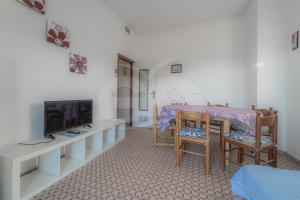 a living room with a table and chairs and a tv at Silvia sul Lungomare di Campo in Marina di Campo
