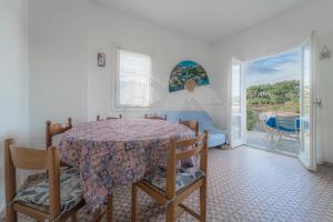 a dining room with a table and a balcony at Silvia sul Lungomare di Campo in Marina di Campo