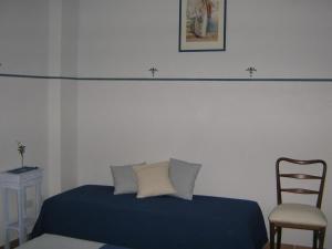 a bedroom with a blue bed and a chair at Ferienwohnung Rose In Cagli in Cagli