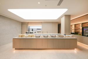 a large kitchen with a large light above a counter at JI Hotel Beijing Guanganmen in Beijing