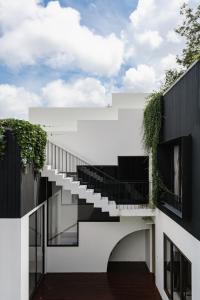 an external view of a white building with stairs at Tree O'clock Pool Villa - Phuket in Thalang