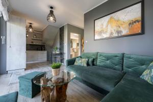 un salon avec un canapé vert et une table dans l'établissement Apartament Pod Małą Czantorią - Dream Apart, à Ustroń