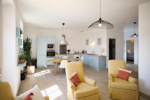 een keuken en een woonkamer met gele stoelen en een tafel bij Chambre d'hôtes Château Gigognan in Sorgues