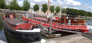 a boat docked at a dock in the water at Boat Hotel SIX Rotterdam in Rotterdam