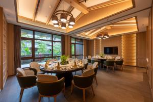 a dining room with tables and chairs and windows at Holiday Inn Pu'er Jingmai by IHG in Mengman