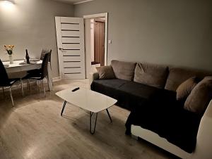 a living room with a couch and a table at Gdańsk - Quiet area with a sea view in Gdańsk