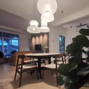 a dining room with a table and chairs and lights at Room Only - RyuiBungalow 23'00-11'00 - Night Use - PROMO in Sungai Petani