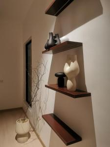 a shelf with vases and vases on a wall at Room Only - RyuiBungalow 23'00-11'00 - Night Use - PROMO in Sungai Petani