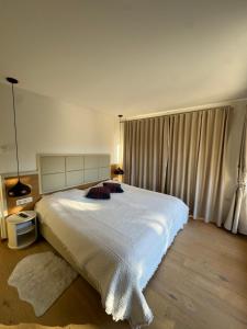 a bedroom with a large white bed with curtains at Alpenzeit Lachtal in Lachtal